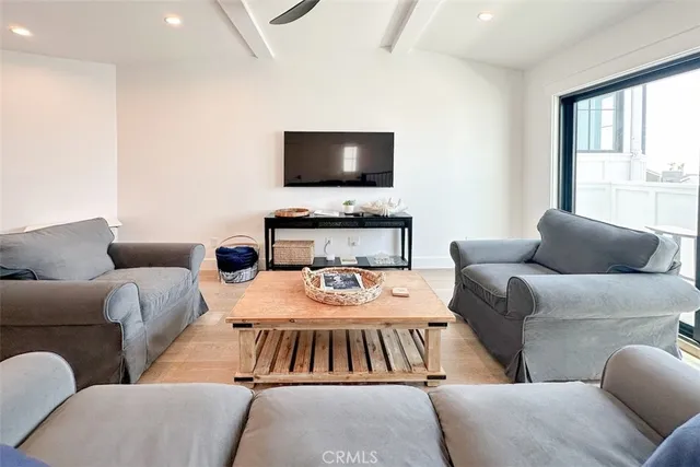 a living room with furniture a flat screen tv and a window