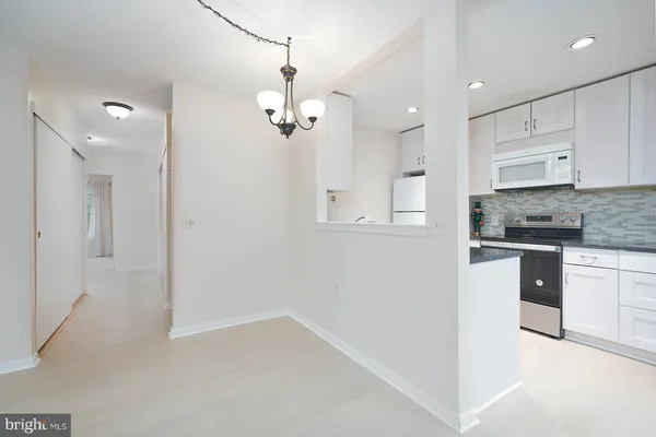 a kitchen with kitchen island white cabinets and refrigerator