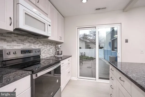 a kitchen with stainless steel appliances granite countertop a stove and a refrigerator