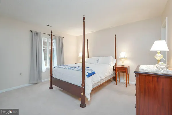 a bedroom with a bed and a dresser next to a window