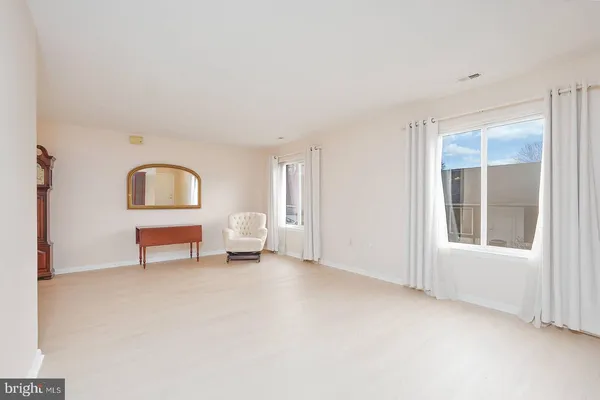 an empty room with windows and cabinet