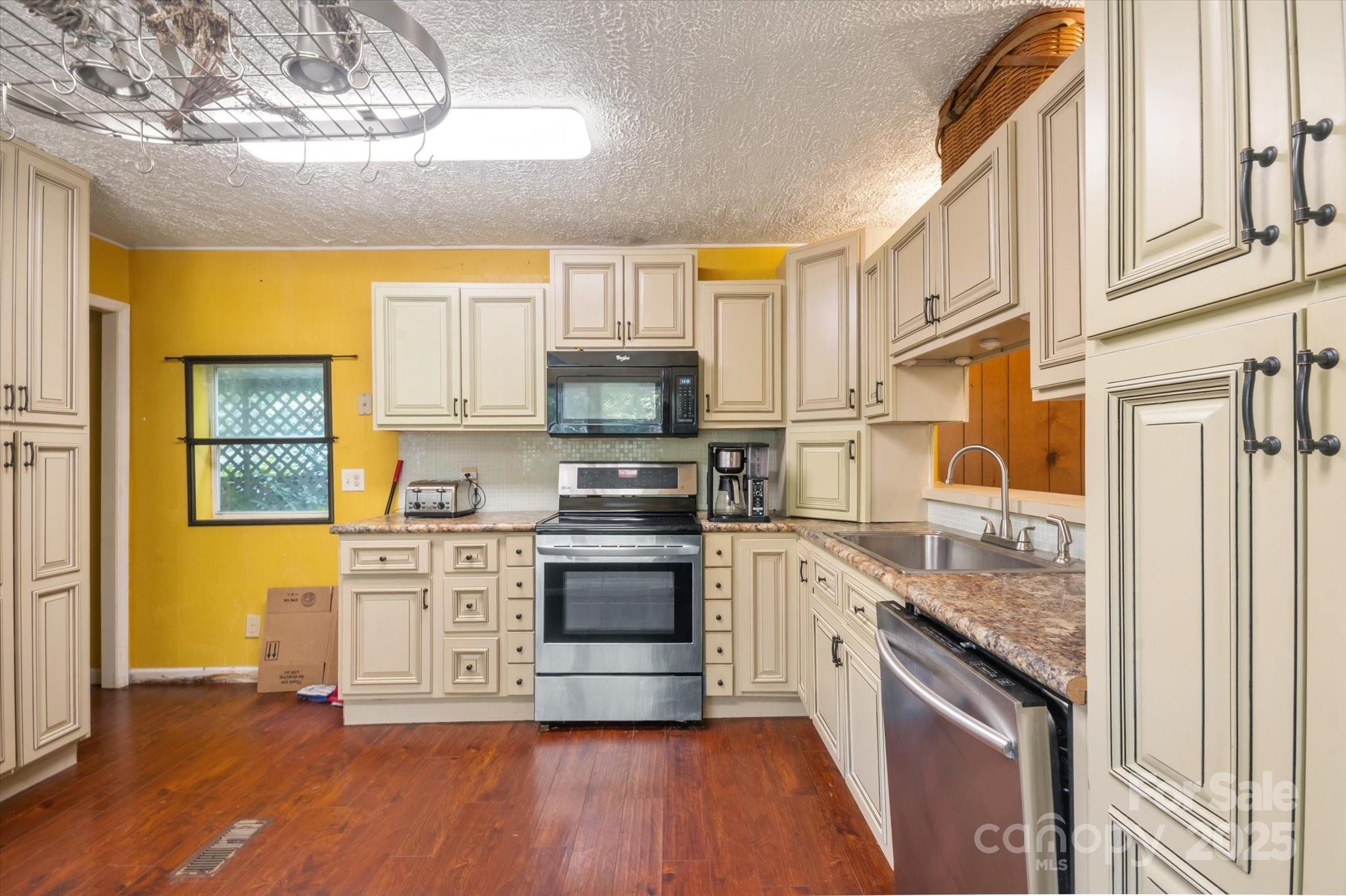 7 Maple Drive Brevard, NC 28712 - Photo 22 of 31 a kitchen with stainless steel appliances granite countertop a stove top oven a sink dishwasher and a refrigerator with wooden floor