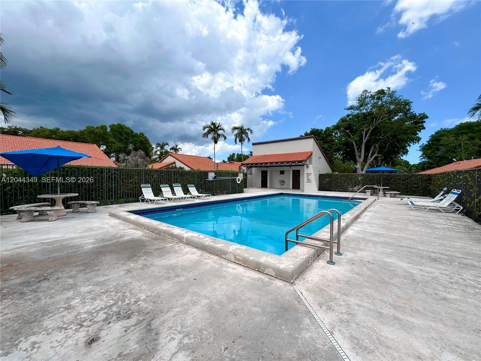 14970 Southwest 48th Terrace, Unit 27G Miami, FL 33185 - Photo 14 of 14 a view of a swimming pool with a lounge chairs