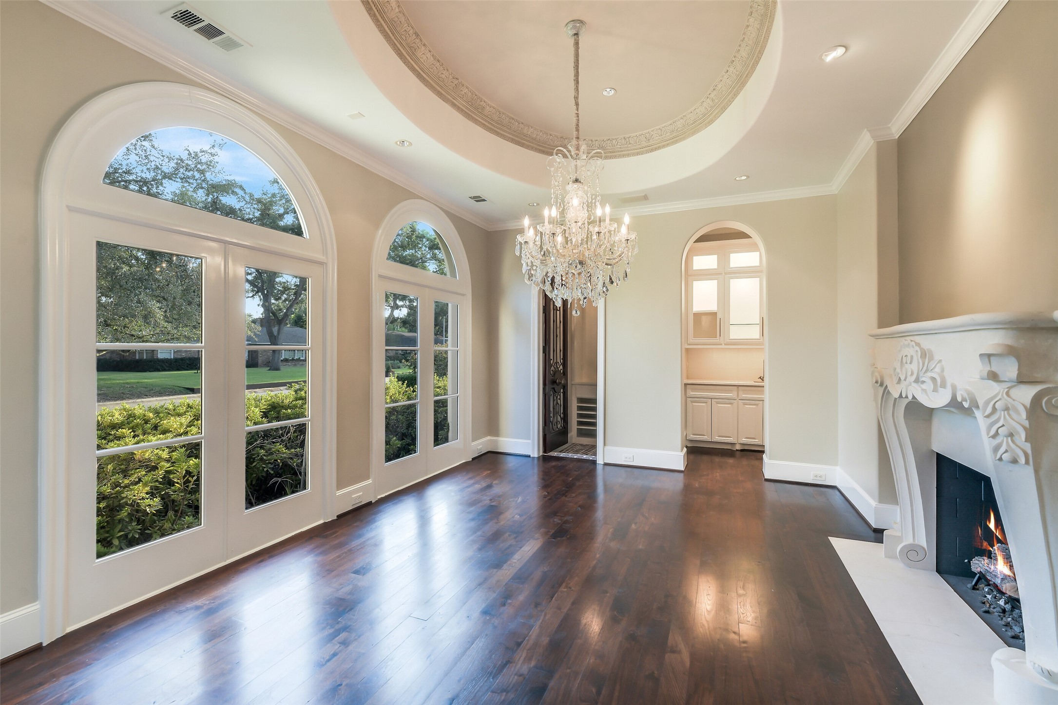 5626 Terwilliger Way Houston, TX 77056 - Photo 39 of 47 an empty room with wooden floor a chandelier and a fireplace