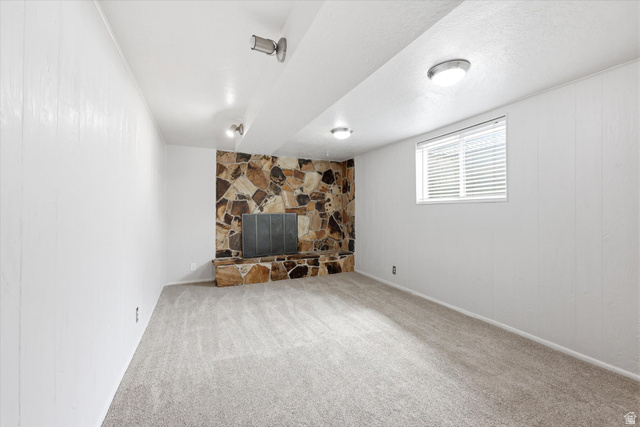215 Carol Way Midvale, UT 84047 - Photo 21 of 30 Basement with a fireplace, carpet floors, wooden walls, and a textured ceiling