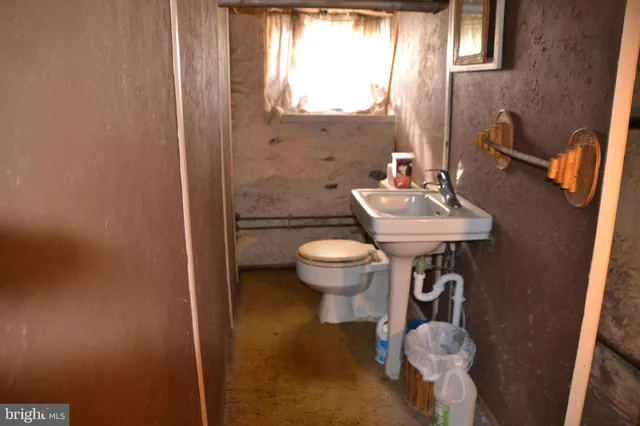 a bathroom with a sink toilet and a mirror