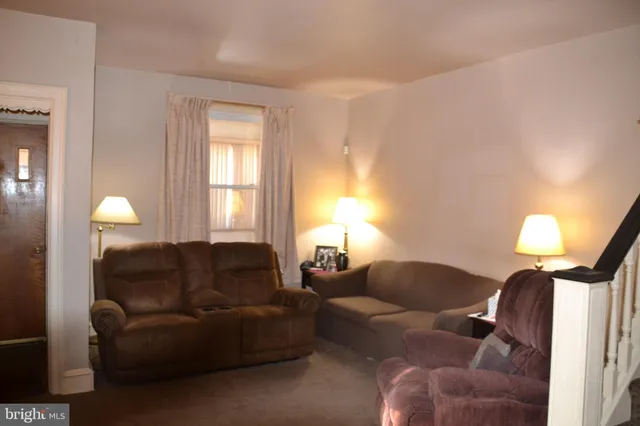 a living room with furniture a window and a lamp