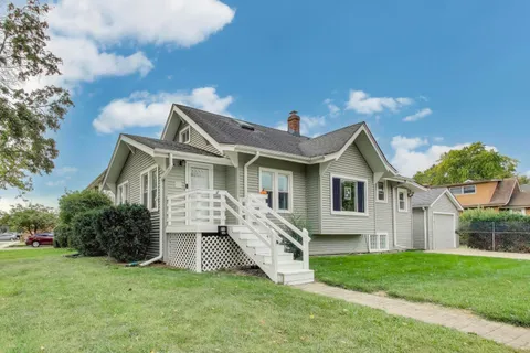 a front view of a house with a yard and trees