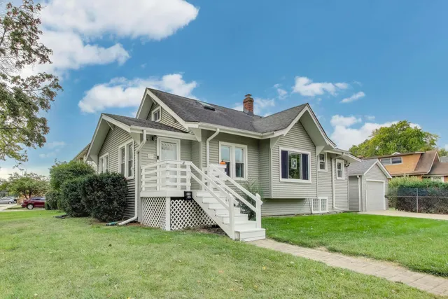 a front view of a house with a yard and trees