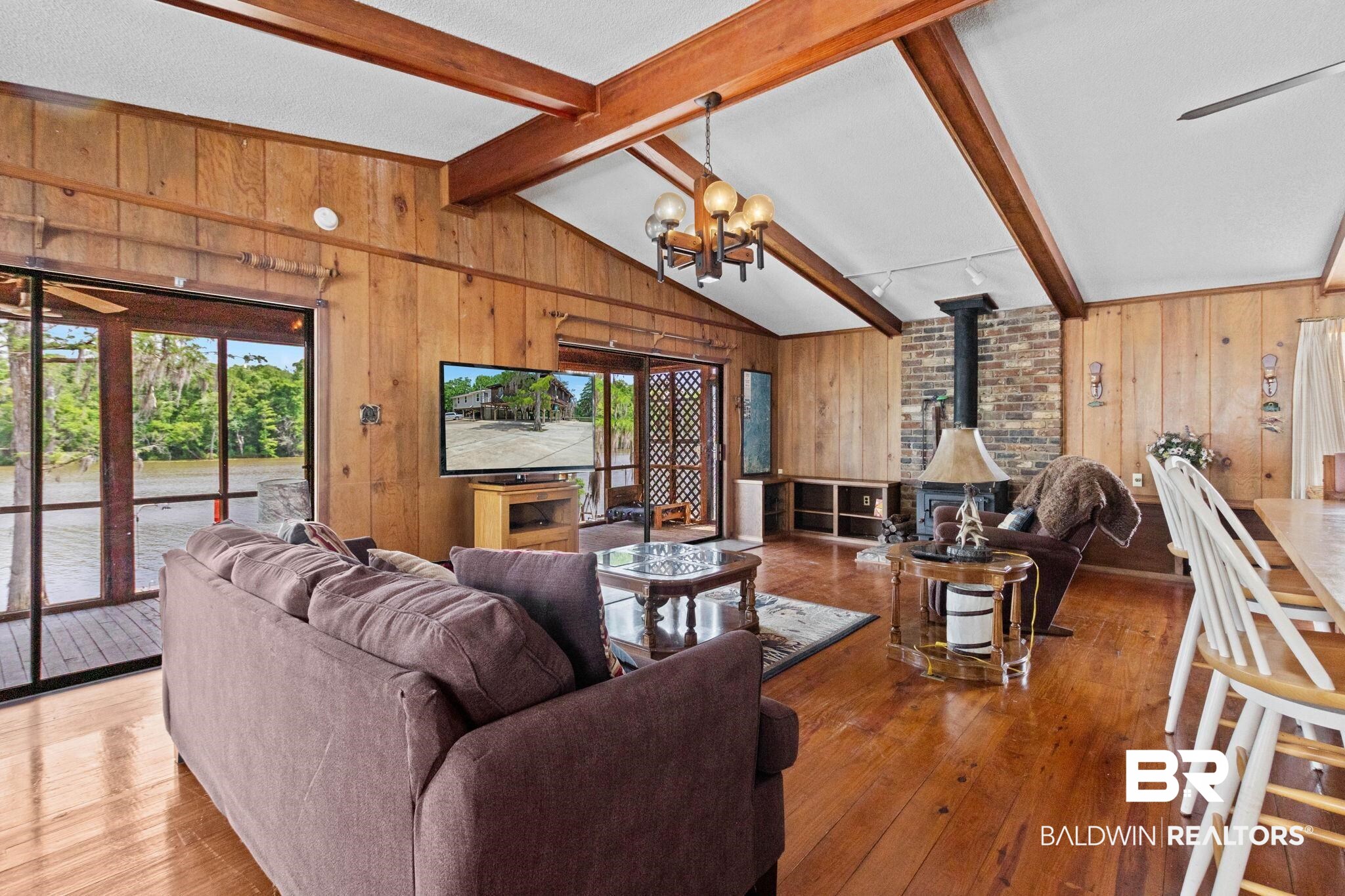 8153 Bryant's Lndg Road Stockton, AL 36579 - Photo 18 of 87 Spacious living area featuring wood-finish flooring, wood-paneled walls, and an exposed beam vaulted ceiling