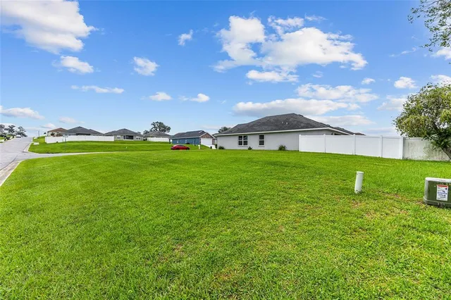 a view of a yard with plants and trees