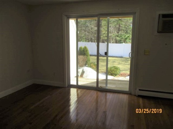 172 Ayer Road, Unit D Shirley, MA 01464 - Photo 5 of 10 a view of an empty room with wooden floor and a window