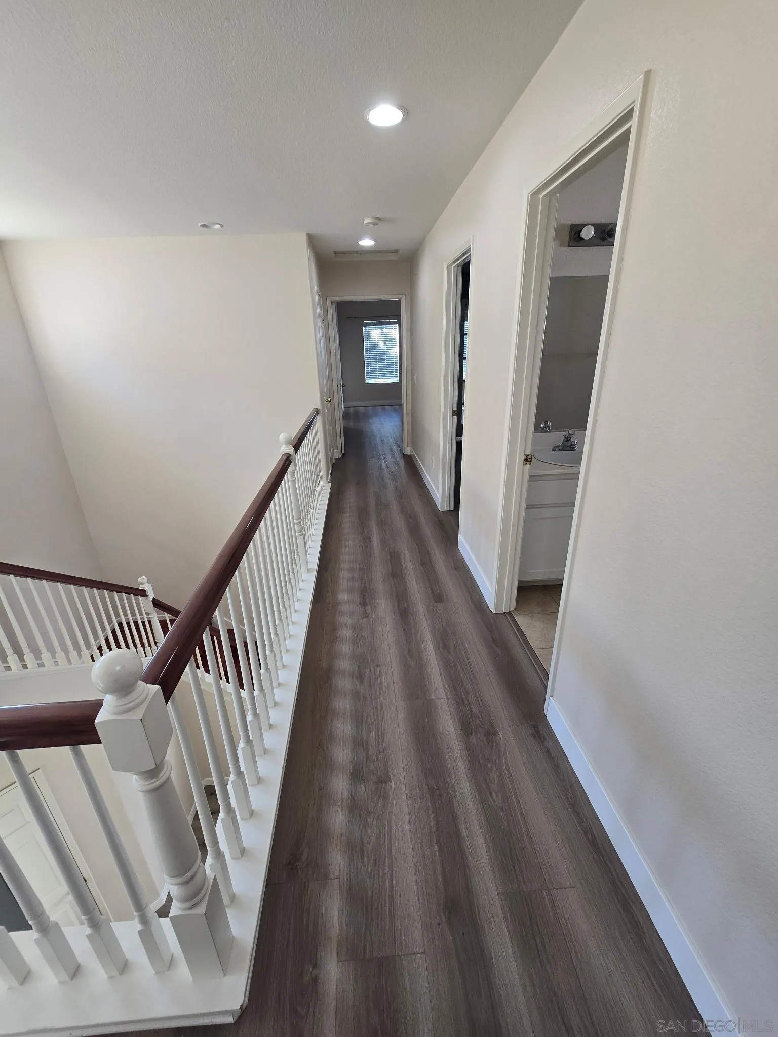 9408 Questa Pointe San Diego, CA 92126 - Photo 4 of 13 a view of a hallway with wooden floor and staircase