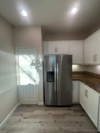 a kitchen with granite countertop a refrigerator and a stove