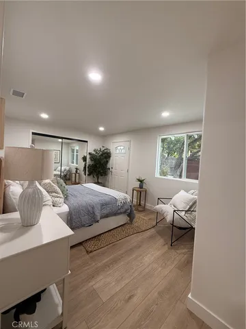 a spacious bedroom with a large bed and a potted plant