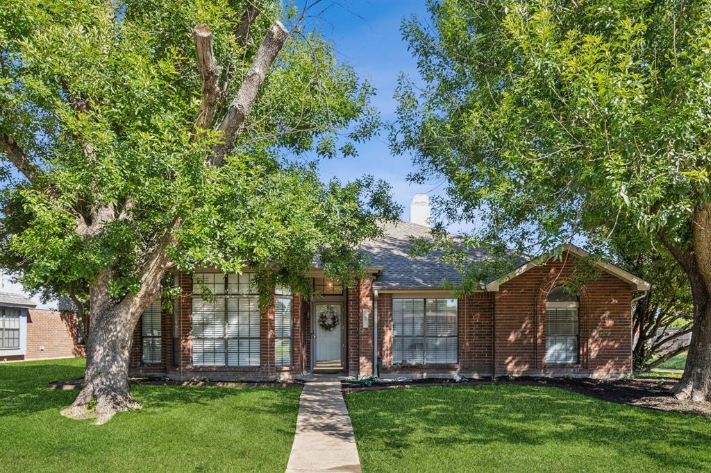a view of a house with garden and trees