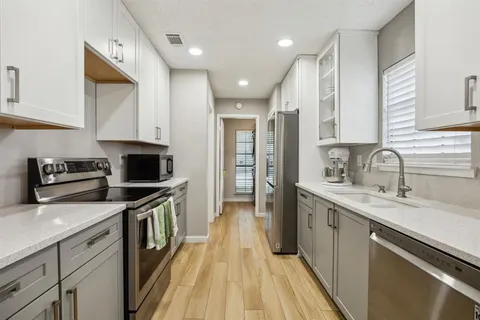 a kitchen with a sink appliances and cabinets