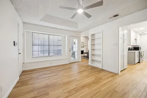 a view of empty room with wooden floor and window