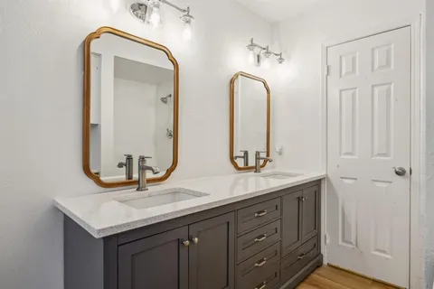 a bathroom with a granite countertop sink and a mirror