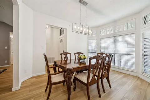 a view of a dining room with furniture wooden floor and chandelier