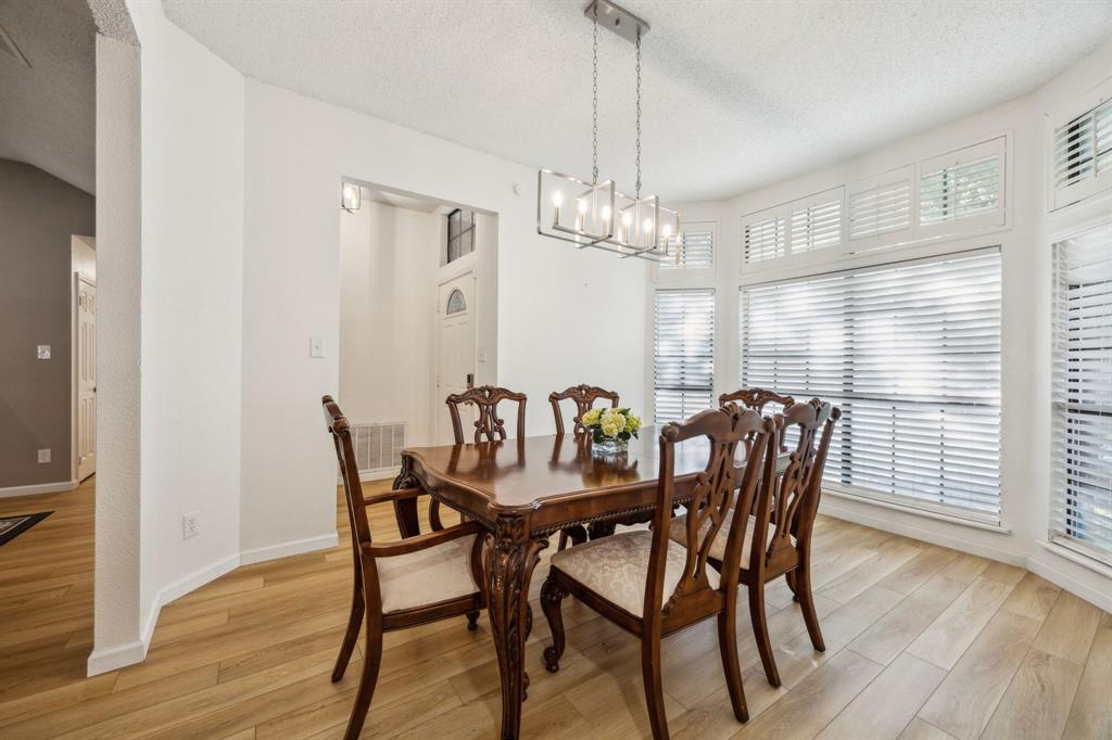 226 East Ridgegate Drive Garland, TX 75040 - Photo 4 of 25 a view of a dining room with furniture wooden floor and chandelier