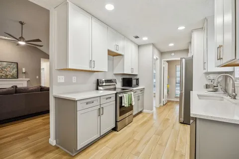 a kitchen with a sink a counter top space stainless steel appliances and cabinets