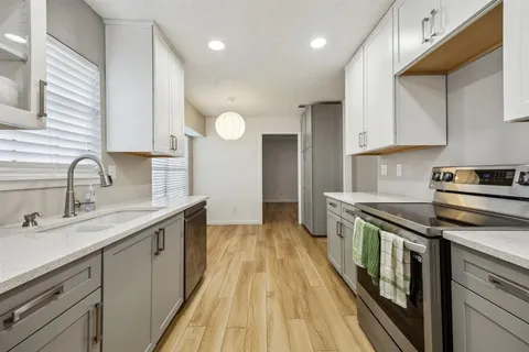 a kitchen with stainless steel appliances granite countertop a sink stove and cabinets