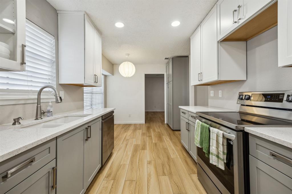 226 East Ridgegate Drive Garland, TX 75040 - Photo 10 of 25 a kitchen with stainless steel appliances granite countertop a sink stove and cabinets