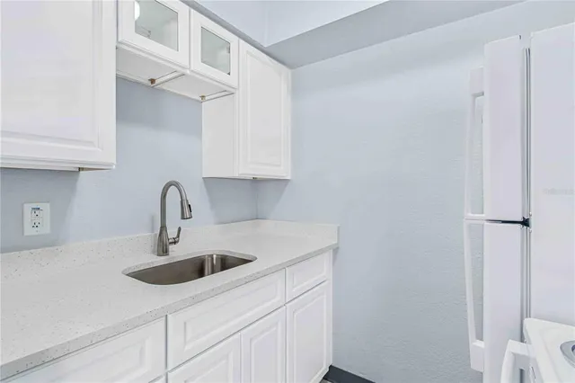 a kitchen with stainless steel appliances granite countertop a sink and a white cabinets