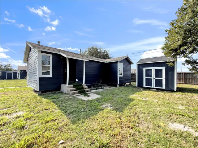 a view of a house with backyard and porch