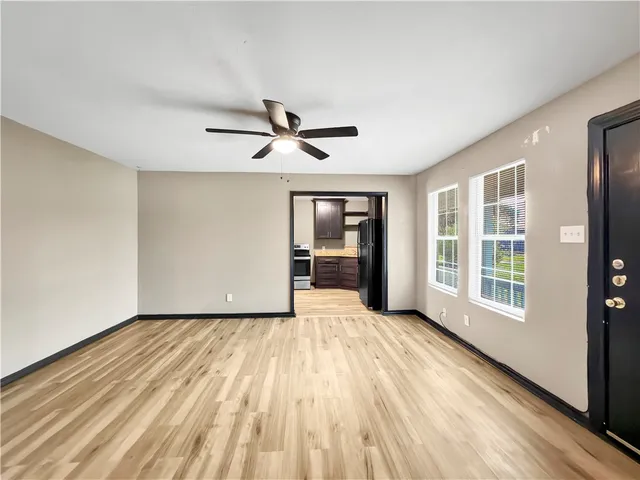 a view of a livingroom with wooden floor and a ceiling fan