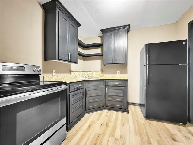 a kitchen with stainless steel appliances granite countertop a refrigerator and a stove