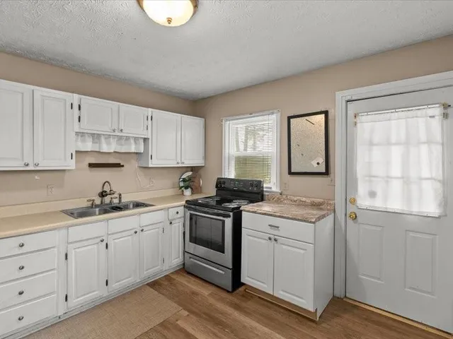 a kitchen with cabinets appliances a sink and a window