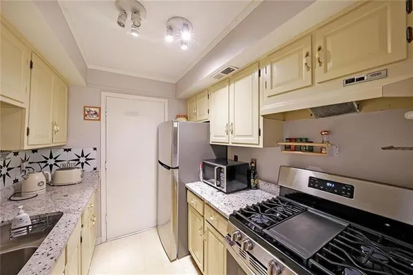 a kitchen with stainless steel appliances granite countertop a stove and a refrigerator
