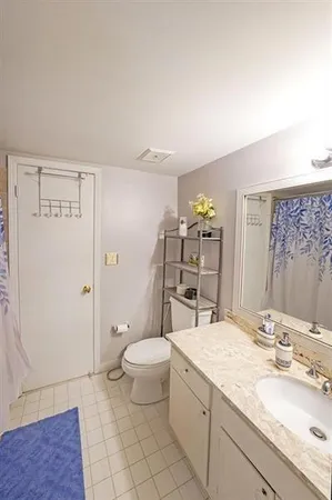 a bathroom with a granite countertop double vanity sink and mirror