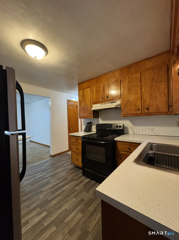 16 Grove Street New London, CT 06320 - Photo 7 of 12 a kitchen with a refrigerator and a stove top oven