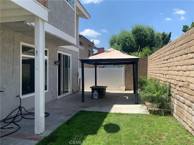 a view of a patio with a table and chairs under an umbrella