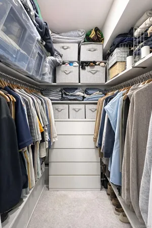 a view of walk in closet with clothes and shoes