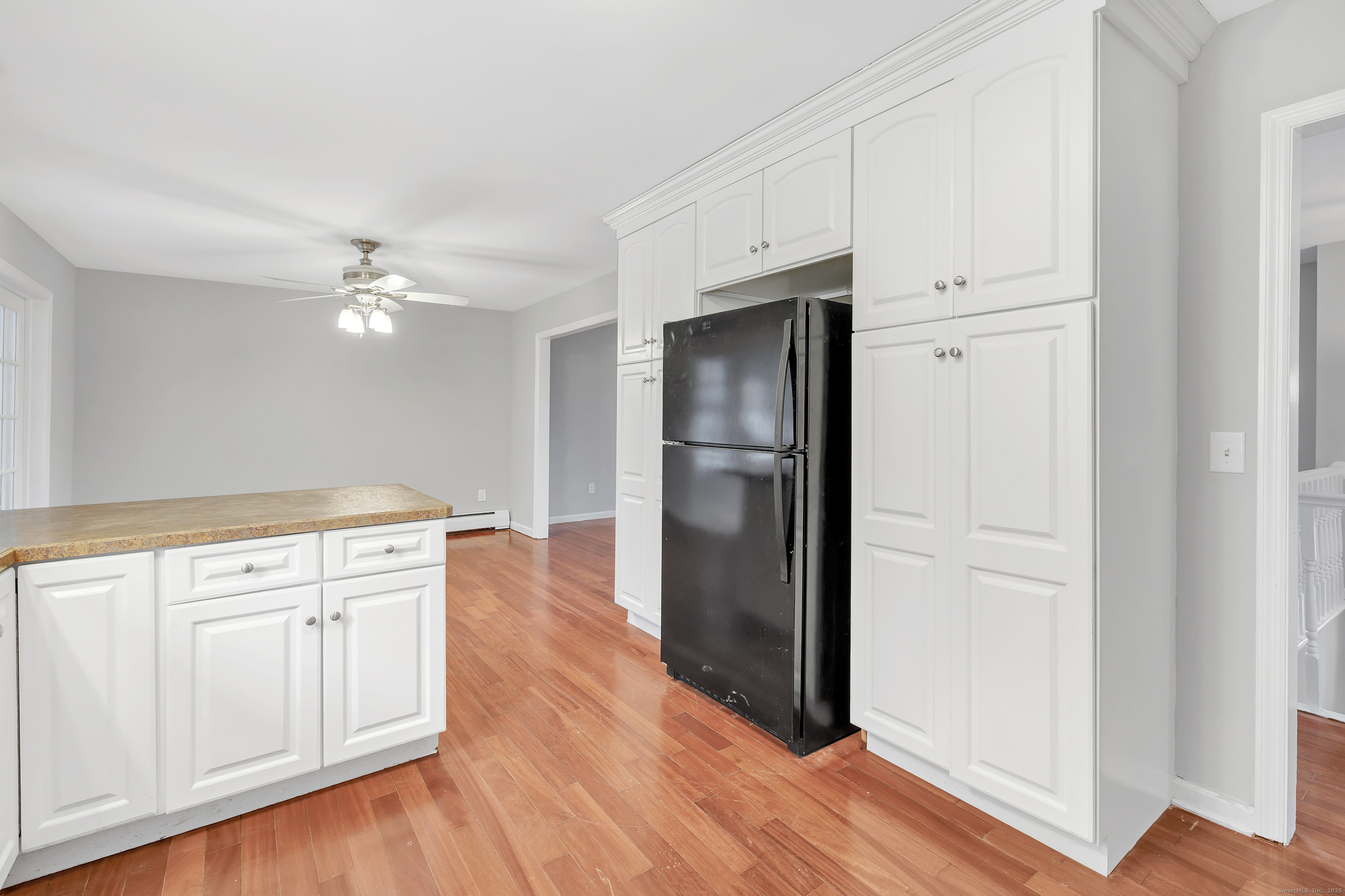 76 Dorman Road Oxford, CT 06478 - Photo 19 of 39 a view of a kitchen with an empty space and wooden floor