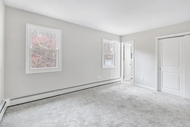 an empty room with windows and closet