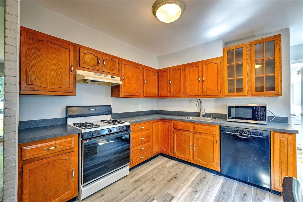 25 Tahanto Road Worcester, MA 01602 - Photo 19 of 35 a kitchen with stainless steel appliances granite countertop wooden cabinets stove top oven and sink