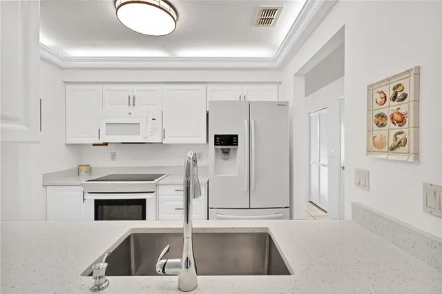 a kitchen with granite countertop a sink a stove and cabinets