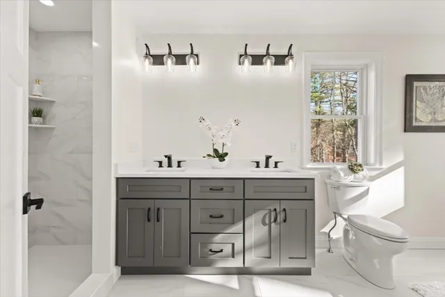 a spacious bathroom with a granite countertop sink a toilet and shower