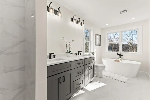 a spacious bathroom with double vanity a window a double vanity and a mirror