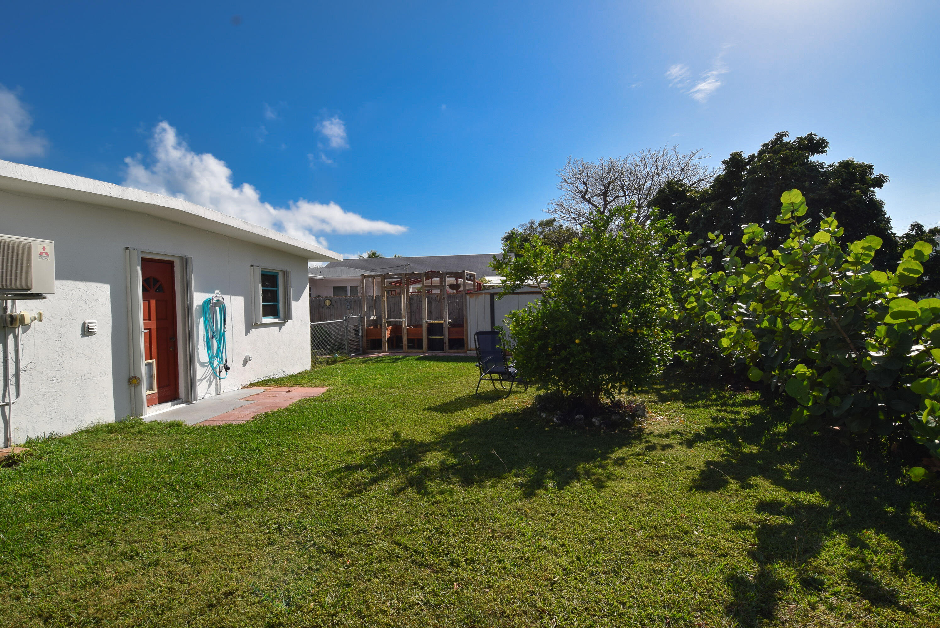 237 2nd Road Key Largo, FL 33037 - Photo 10 of 25 a backyard of a house with table and chairs plants and large tree