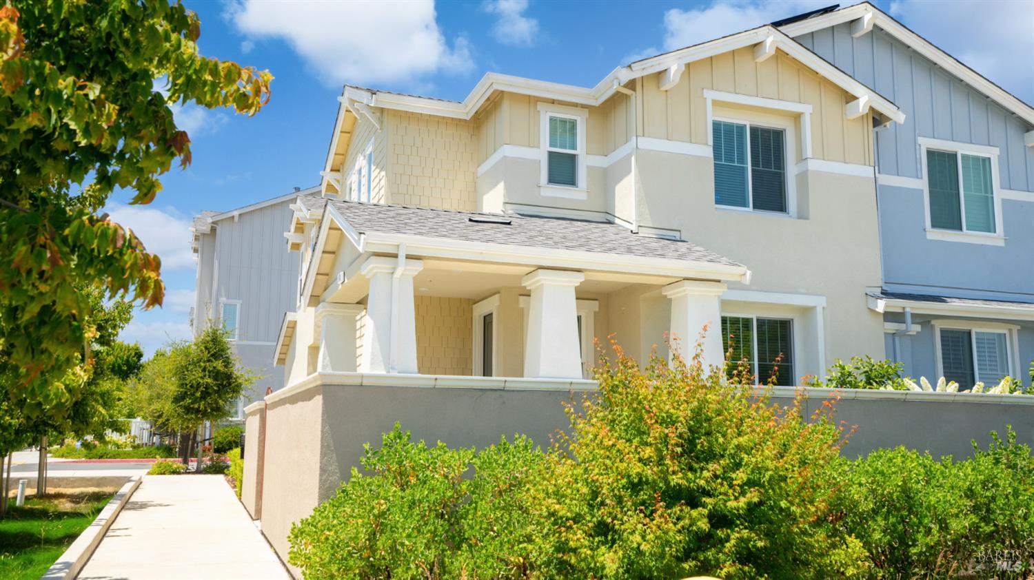 a view of a white house with large windows and a small yard