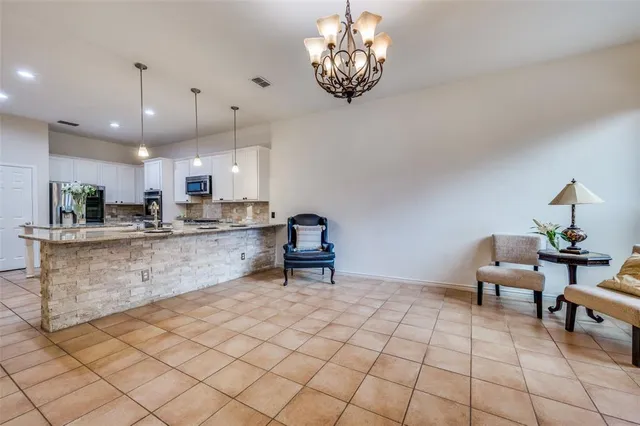 a kitchen with stainless steel appliances granite countertop a sink and a refrigerator