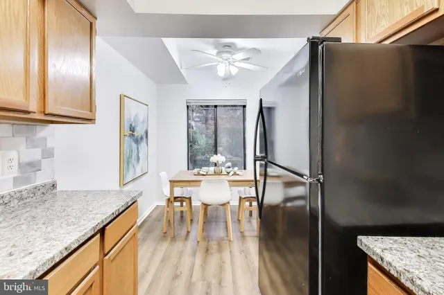 a kitchen with a table chairs refrigerator and cabinets