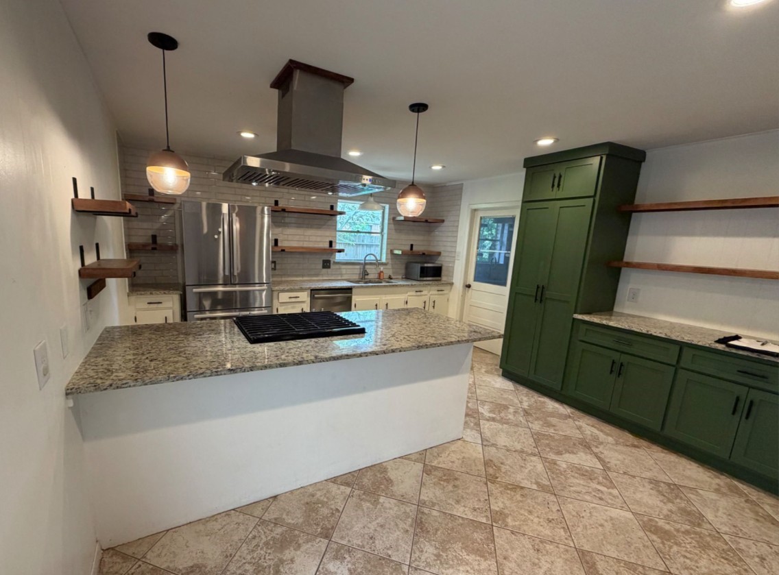 7314 Cannock Road Houston, TX 77074 - Photo 5 of 6 a large kitchen with granite countertop a large kitchen island in the center and a large mirror