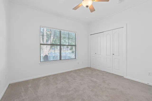 an empty room with chandelier fan